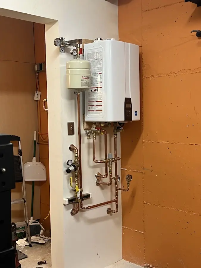 Plumbing technician inspecting water heater connections in Cedarville